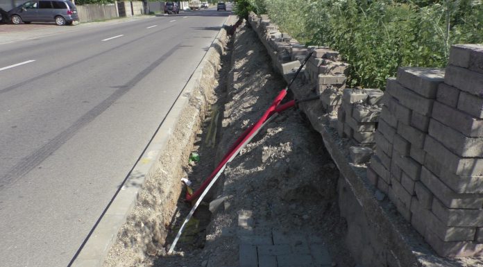 Stâlpi de iluminat stradal, pe un trotuar îngust